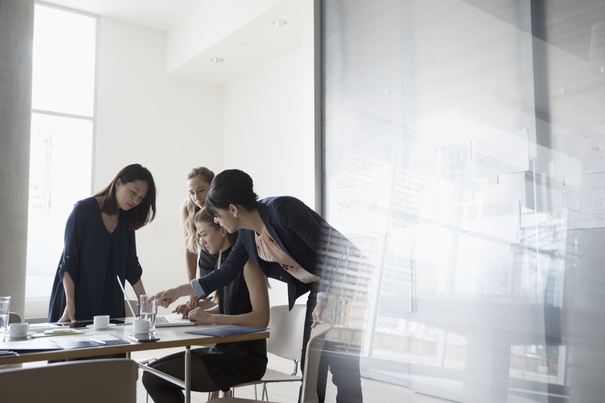 Businesswomen-brainstorming-around-a-laptop